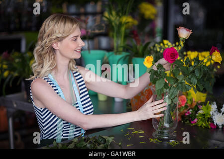 Weibliche Floristen arrangieren Blumenstrauß in vase Stockfoto