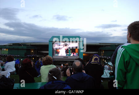 Fans beobachten von Henman Hill aus, wie der britische Tim Henman während der All England Lawn Tennis Championship in Wimbledon den spanischen Carlos Moya spielt. Stockfoto