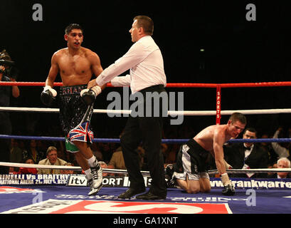 Der englische Amir Khan wird vom Schiedsrichter weggeführt, nachdem er während des Commonwealth Lightweight Title Fight in der O2 Arena in London den schottischen Willie Limond zu Boden gestoßen hat. Stockfoto