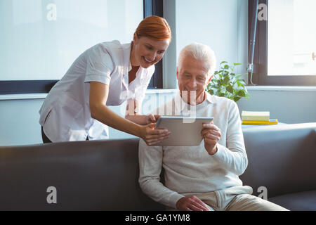 Krankenschwester und Senior Mann mit einem digitalen tablet Stockfoto