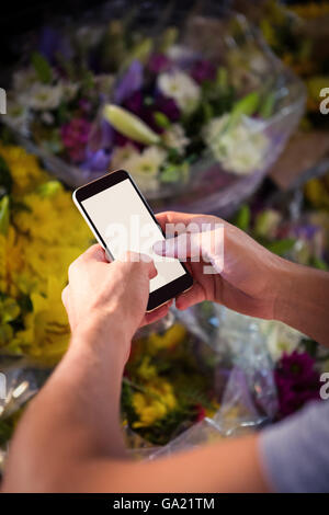 Männliche Florist SMS auf Handy Stockfoto