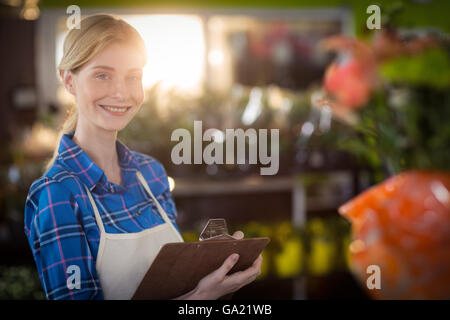 Weibliche Florist stehend mit Zwischenablage Stockfoto