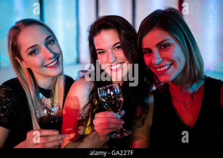 Lächelnd Freunden zusammensitzen und Wein Stockfoto