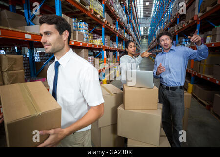 Mitarbeiter sprechen und zeigen Regale Stockfoto