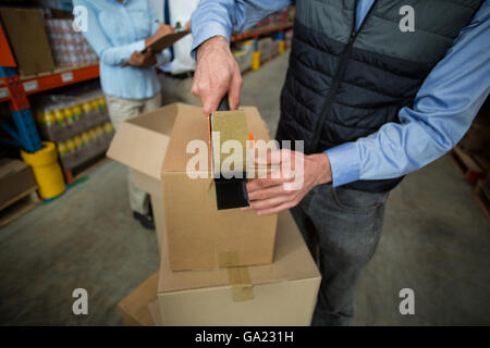 Nahaufnahme von Manager Hände einen Karton abkleben Stockfoto