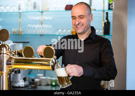 Barkeeper Bier aus bar Pumpe füllen Stockfoto