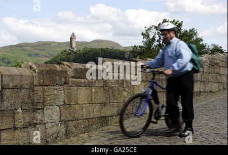 Abgebildet ist eine allgemeine Ansicht eines Touristen auf dem Alte Stirlingbrücke, die den Fluss Forth bei Stirling überquert Mit dem Wallace Monument (hinten) Stockfoto