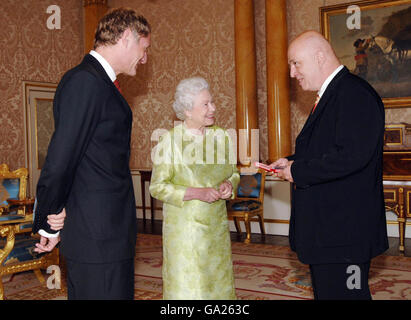 Die britische Königin Elizabeth II. Überreicht die Goldmedaille der Königin für Poesie an James Fenton, rechts, der vom Poeten Laureate Professor Andrew Motion im Buckingham Palace, London, begleitet wurde. Stockfoto