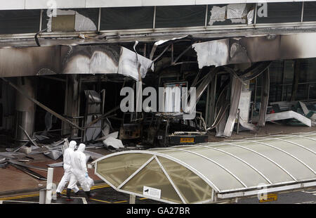 Forensische Polizeibeamte machen sich auf den Weg zum Schauplatz des gestrigen dramatischen Angriffs auf das Terminalgebäude am Flughafen Glasgow. Stockfoto