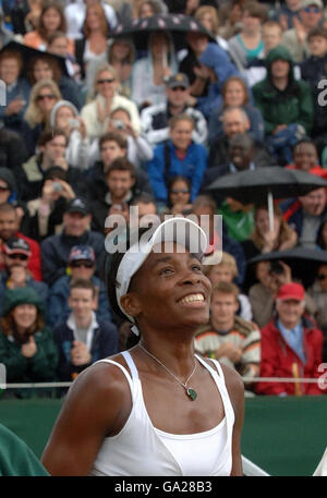 Die US-Amerikanerin Venus Williams lächelt nach ihrem Sieg gegen Akiko Morigami, als während der All England Lawn Tennis Championship in Wimbledon Regen zu fallen beginnt. Stockfoto