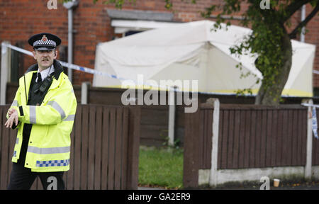 Ein Polizeibeamter, der vor einem Grundstück auf der Thelwall Avenue in Fallowfield, im Süden von Manchester, Dienst hat. Stockfoto