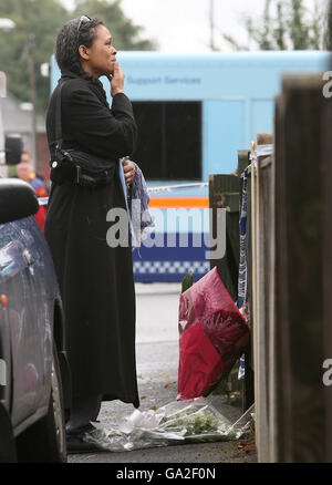 Eine namenlose Frau zeigt Emotionen außerhalb des Hauses in Fallowfield, Manchester, wo drei Leichen gefunden wurden. Stockfoto