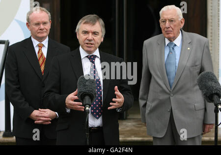 Waliser Vize-Premierminister Ieuan Wyn Jones (Mitte) spricht zu den Medien, während der nordirische Vize-Premierminister Martin McGuiness (links) und der nordirische Erstminister Dr. Ian Paisley vor einer Sitzung des britisch-irischen Rates zusehen, in der die Leiter aller dezentralen Verwaltungen im Vereinigten Königreich zusammenkommen, Am Parlamentsgebäude, Stormont. Stockfoto