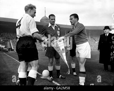 Der englische Kapitän Billy Wright (l) tauscht Wimpel mit dem ungarischen Kapitän Ferenc Puskas (r) beim Münzwurf aus, beobachtet von Schiedsrichter Leo Horn (c) Stockfoto