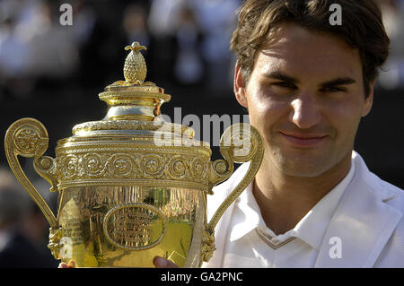 Der Schweizer Roger Federer hält die Trophäe, nachdem er das Herrenfinale gegen den spanischen Rafael Nadal während der All England Lawn Tennis Championship in Wimbledon gewonnen hat. Stockfoto