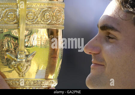 Der Schweizer Roger Federer hält die Trophäe, nachdem er das Herrenfinale gegen den spanischen Rafael Nadal während der All England Lawn Tennis Championship in Wimbledon gewonnen hat. Stockfoto