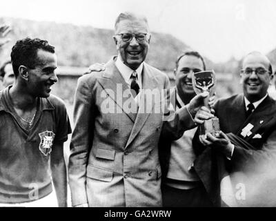 König Gustaf VI Adolf von Schweden (c), im Begriff, die Weltmeisterschaft an die siegreiche brasilianische Mannschaft zu präsentieren, von Brasiliens Zito (l) Stockfoto