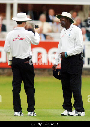 Die Bahnschiedsrichter Simon Taufel (links) und Steve Bucknor lesen leicht, bevor sie die Spieler beim ersten npower-Test zwischen England und Indien im Lord's Cricket Ground, London, für schlechtes Licht ausziehen. Stockfoto