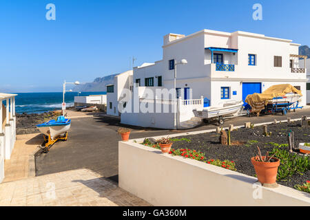 Häuser mit Angelboote/Fischerboote in Famara Dorf auf der Insel von Lanzarote, Spanien Stockfoto