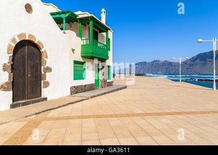 Weiße Kirche und typisch kanarisches Haus in Famara Dorf auf der Insel von Lanzarote, Spanien Stockfoto