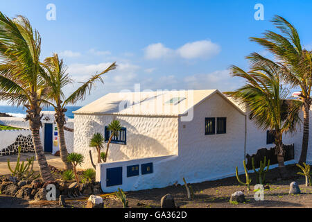 Strand von EL GOLFO, Insel LANZAROTE - 15. Januar 2015: Typische weiße Haus und Palmen Baum in El Golfo Dorf auf der Insel von Lanzarote, Spanien. Kanarischen Inseln sind ein beliebtes Urlaubsziel. Stockfoto