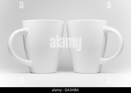 Zwei weiße Tassen in einer gespiegelten Anordnung in High key Stockfoto