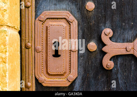 Alten Eisen Schlüsselloch auf schwarzen Holztür. Stockfoto