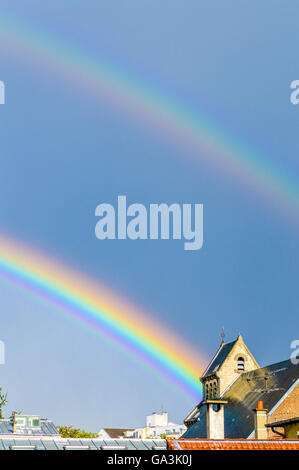 doppelter Regenbogen über ein Kirchendach Stockfoto