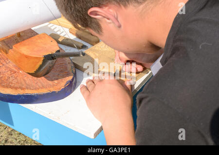 Kind mit Handwerkzeugen, Holz für Bastelaktion schnitzen Stockfoto