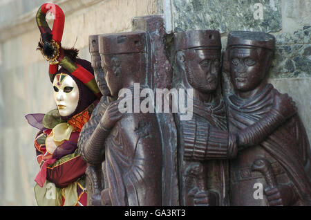 Masketeers in aufwendigen dekorativen Kostüm posiert neben Statuen auf der Venedig-Maske-Festival Stockfoto