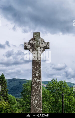 Alte hohe Keltisches Kreuz eingeschrieben mit Bibelvers aus dem gälischen mit legendären schottischen Landschaft im Hintergrund. Stockfoto