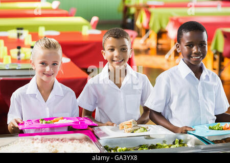 Porträt von Schulkindern mit Mittagessen während der Pausenzeit Stockfoto