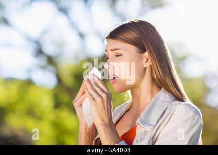 Schöne Frau mit Gewebe beim Niesen Stockfoto