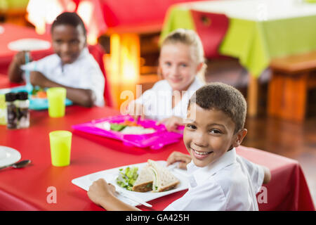 Kinder während der Pausen in der Cafeteria der Schule zu Mittag Stockfoto