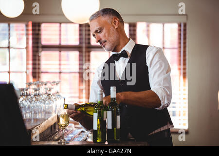 Barkeeper Rotwein in ein Glas gießen Stockfoto