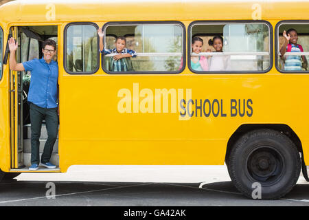 Porträt von Lehrer und Kinder winken Hand vom bus Stockfoto