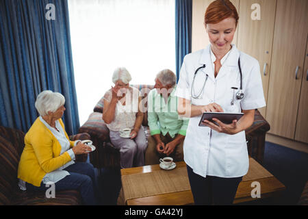 Porträt einer lächelnden Krankenschwester mit Senioren Stockfoto