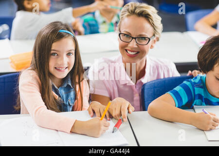 Lehrer helfen, eine Mädchen mit Studie im Klassenzimmer Stockfoto