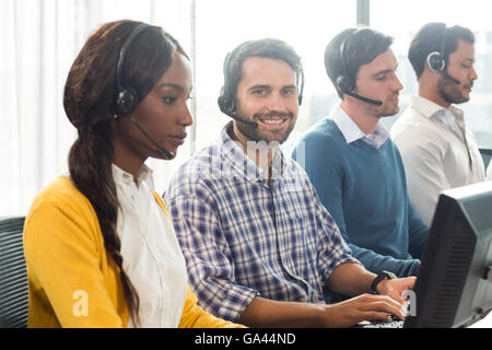 Team arbeiten am Computer mit Headset Stockfoto