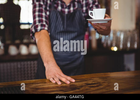 Kellner, die Übergabe eines Kaffees Stockfoto