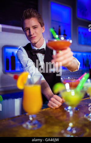 Porträt des Lächelns Barkeeper Holding Cocktailglas Stockfoto