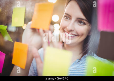 Kreative Geschäftsfrau auf Notizzettel schreiben Stockfoto