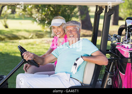 Fröhliche ältere Golfer paar sitzt im Golfbuggy Stockfoto