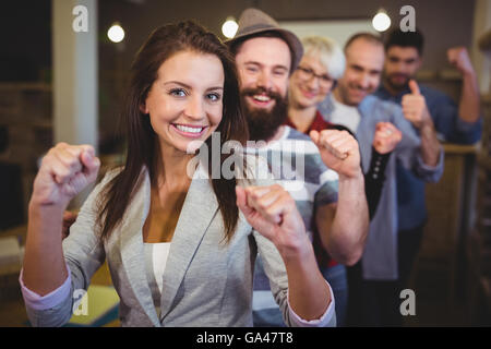 Mitarbeiter, die mit geballter Faust in Kreativbüro jubeln Stockfoto