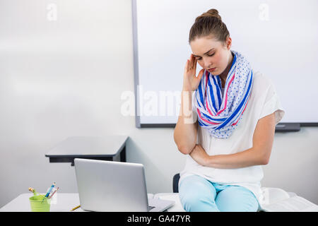 Lehrer leiden unter Kopfschmerzen beim Sitzen im Klassenzimmer Stockfoto