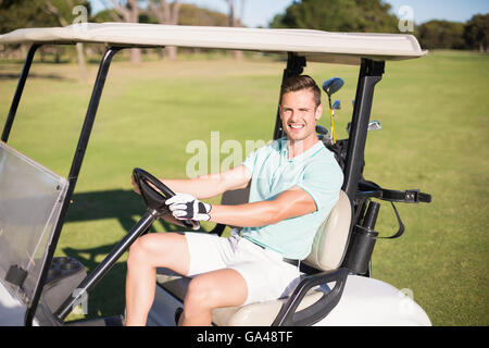 Glücklich Golfer Mann Golfbuggy fahren Stockfoto