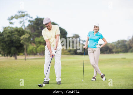 Golfen im stehen von Frau Mann Stockfoto