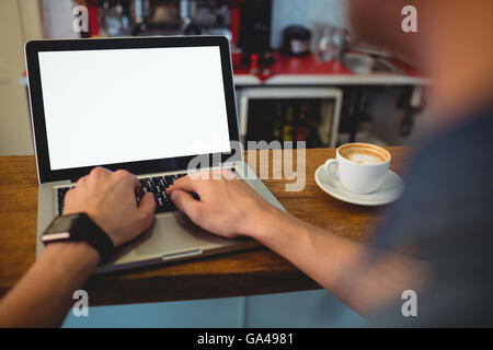 Bild des Kunden Tippen auf Laptop im Café beschnitten Stockfoto