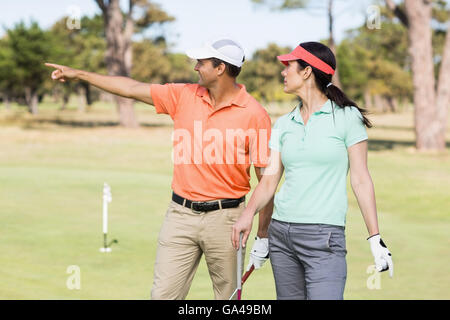 Lächelnd Golfer Mann zeigte Frau stehend Stockfoto