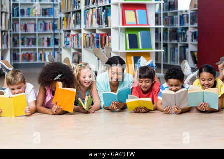 Lehrer mit Studenten, die Bücher zu lesen, beim hinlegen Stockfoto